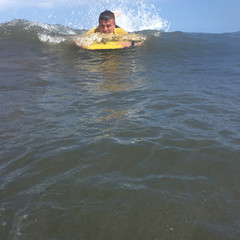 Man riding on bodyboard in ocean - 172682172