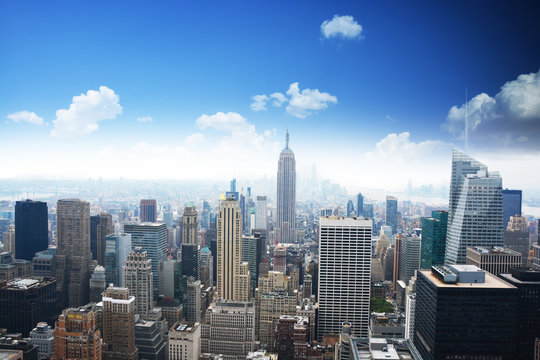 Manhattan panorama in summer time with blue sky, Empire State Building in the center of the picture