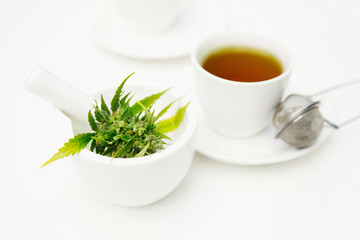 Cannabis leaves or marijuana leaves in a mortar tea cup