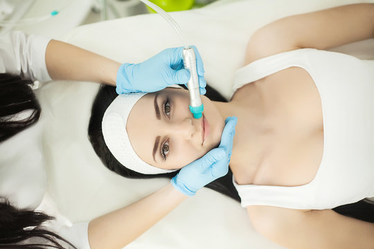 Girl lying in beauty spa enjoying skin therapy using current treatment