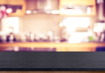 Empty black wooden table top with blurred home kitchen,Mock up template for display or montage of...