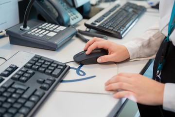 Receptionists Hand Using Computer Mouse At Desk In Airport