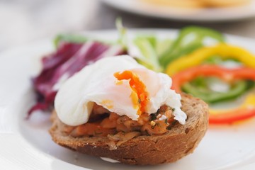 Healthy Breakfast with Wholemeal Bread Toast and Poached Egg with fresh Vegetables on dish.