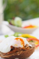 Healthy Breakfast with Wholemeal Bread Toast and Poached Egg with fresh Vegetables on dish.