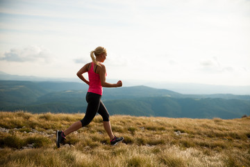 Fototapeta premium runner - woman runs cros country on a path in early autumn