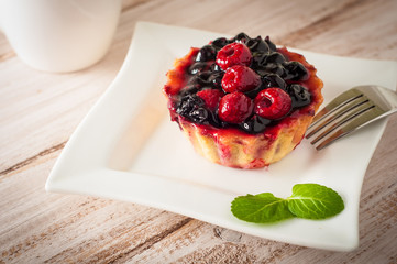 Fresh berry tartlet or cake filled with custard, raspberry, blueberry redcurrant and blackberry delicious dessert, easy diet. Close up