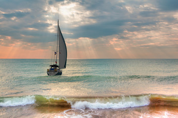 Lone yacht sailing in the Aegean sea at sunset
