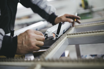 Manual worker assembling PVC doors and windows. Manufacturing jobs. Selective focus. Factory for aluminum and PVC windows and doors production.