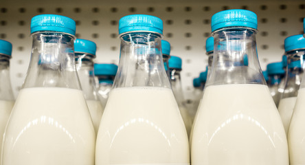 bottles with milk as dairy product for preparing breakfast wait for byers on market shelf