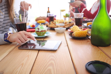 Top view of group of people having dinner together while sitting at wooden table. Food on the table. People eat fast food.