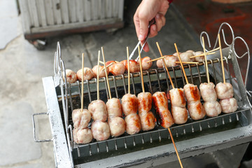 Local seller cook Northeast Thai style meat sausage at Bangrak market, Bangkok, Thailand