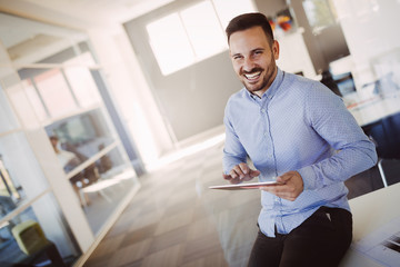 Portrait of handsome successful architect holding tablet