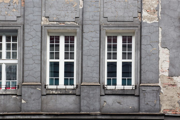 The shabby facade of the grey house.