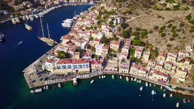 August 2017: Aerial drone video of picturesque port of Symi island with colourful neoclassic houses, Dodecanese, Aegean, Greece