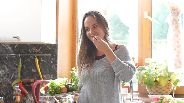 Smiling woman on a diet sitting and looking at camera. A vegetarian girl eating a salad.