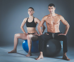Obraz premium Two smiling people with fitness ball in the gym. Personal fitness instructor. Personal training. Gym workout.