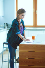 Beautiful young smiling female doctor sitting at the desk and writing.