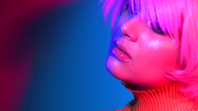Fashion model woman in colorful bright lights, portrait of beautiful party girl with trendy makeup, manicure and haircut. 4K UHD video 3840x2160