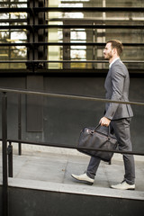 Businessman in suit with leather handbag goes to work