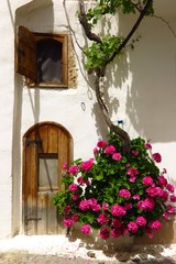 arched doorway in Kritsa village, Crete, Greece with blooming flower vine
