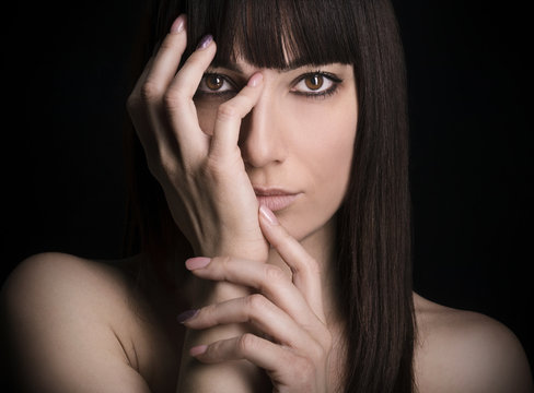 Donna con capelli neri e mani sul volto
