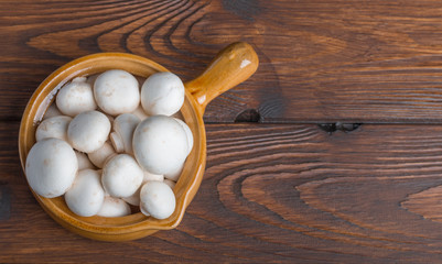 mushrooms and stone casserole on a wooden table