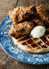 Chicken wings and waffles served with butter and blackberry syrup