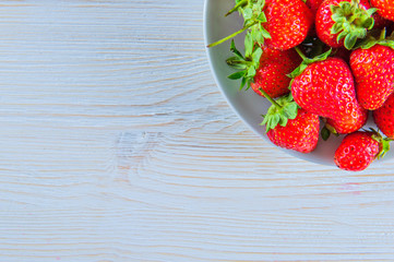 Strawberries on white wooden table.