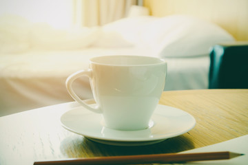 Hot cup of coffee on wooden table in bedroom fresh morning concept