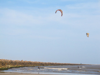 People windsurfing at Cassino beach in Rio Grande, Brazil - breakwater in the background