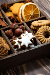 wooden box with Christmas sweets and spices on wooden background, vertical closeup