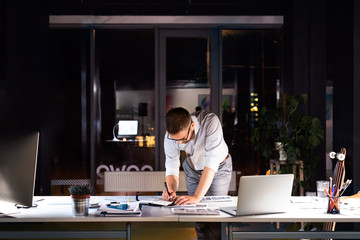 Businessman in the office at night working late.