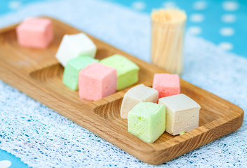 Sweet marshmallows on wooden plate