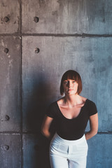 young model beautiful indoor looking camera lying on concrete wall - influencer, blogger, natural beauty concept