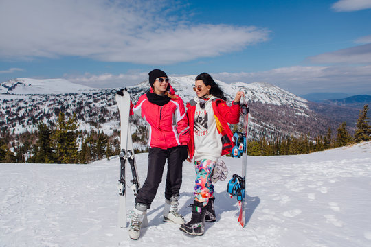 Two youn women with ski and snowboard