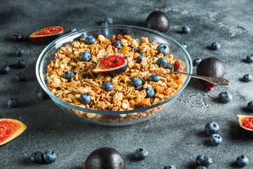 Homemade muesli with nuts in glass bowl, berries and figs fruits. Healthy natural breakfast.