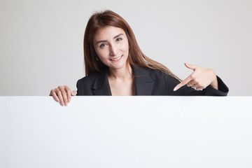Fototapeta premium Young Asian woman point to a blank sign.