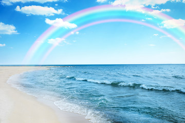Beautiful beach at sea resort and rainbow in sky