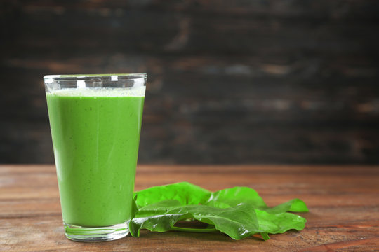 Glass of spinach smoothie on table