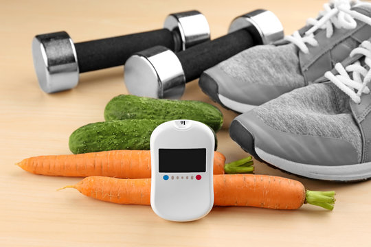 Composition with digital glucometer, vegetables and sport inventory on light background. Diabetes concept