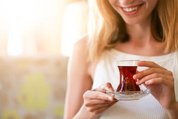 Woman drinking delicious traditional Turkish tea in cafe