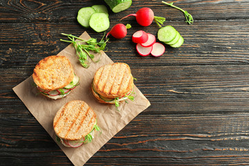 Tasty sandwiches with fresh cucumber on wooden background