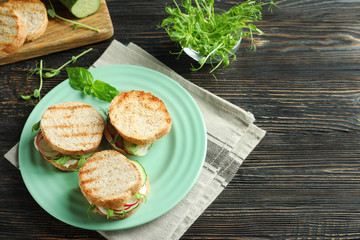 Plate of tasty sandwiches with fresh cucumber on table
