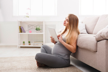 Young pregnant woman using tablet