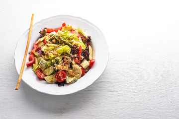 Salad of fresh vegetables and gorgonzola cheese. On a wooden background. Top view. Free space.