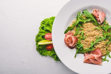 Risotto with diced meat and arugula. Top view. Free space.