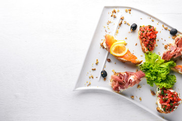 Bruschetta Sandwich with salmon and hamoon. On a wooden background. Top view. Free space.