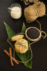 Sesame Cookies, sesame and milk on black wooden background