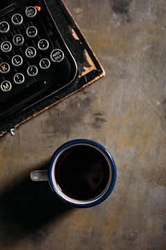 Enamel cup with coffee and retro typewriter