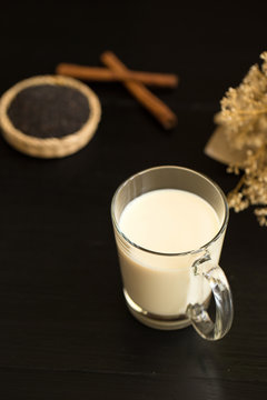 Glass of milk on black wooden background